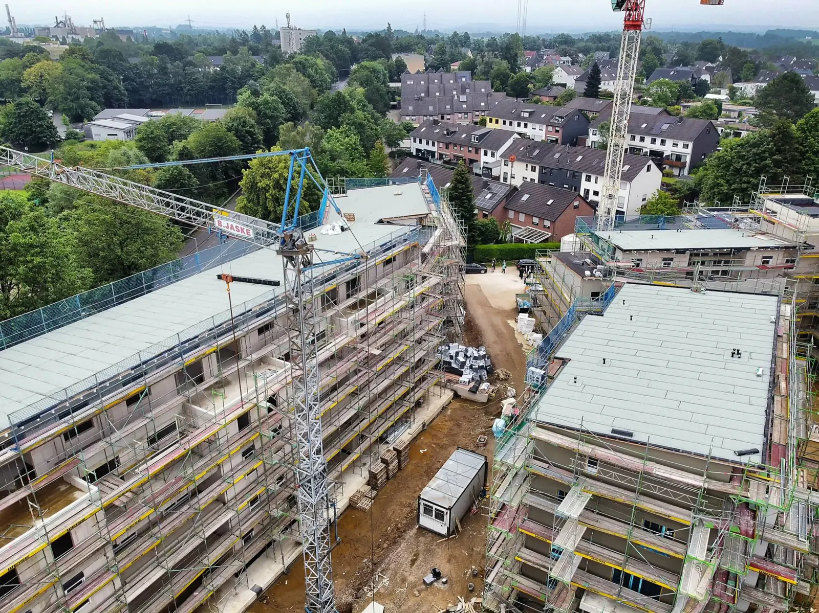 Wohnanlage in Mettmann aus der Luft während der Bauzeit, zwei eingerüstete Baukörper mit Kränen
