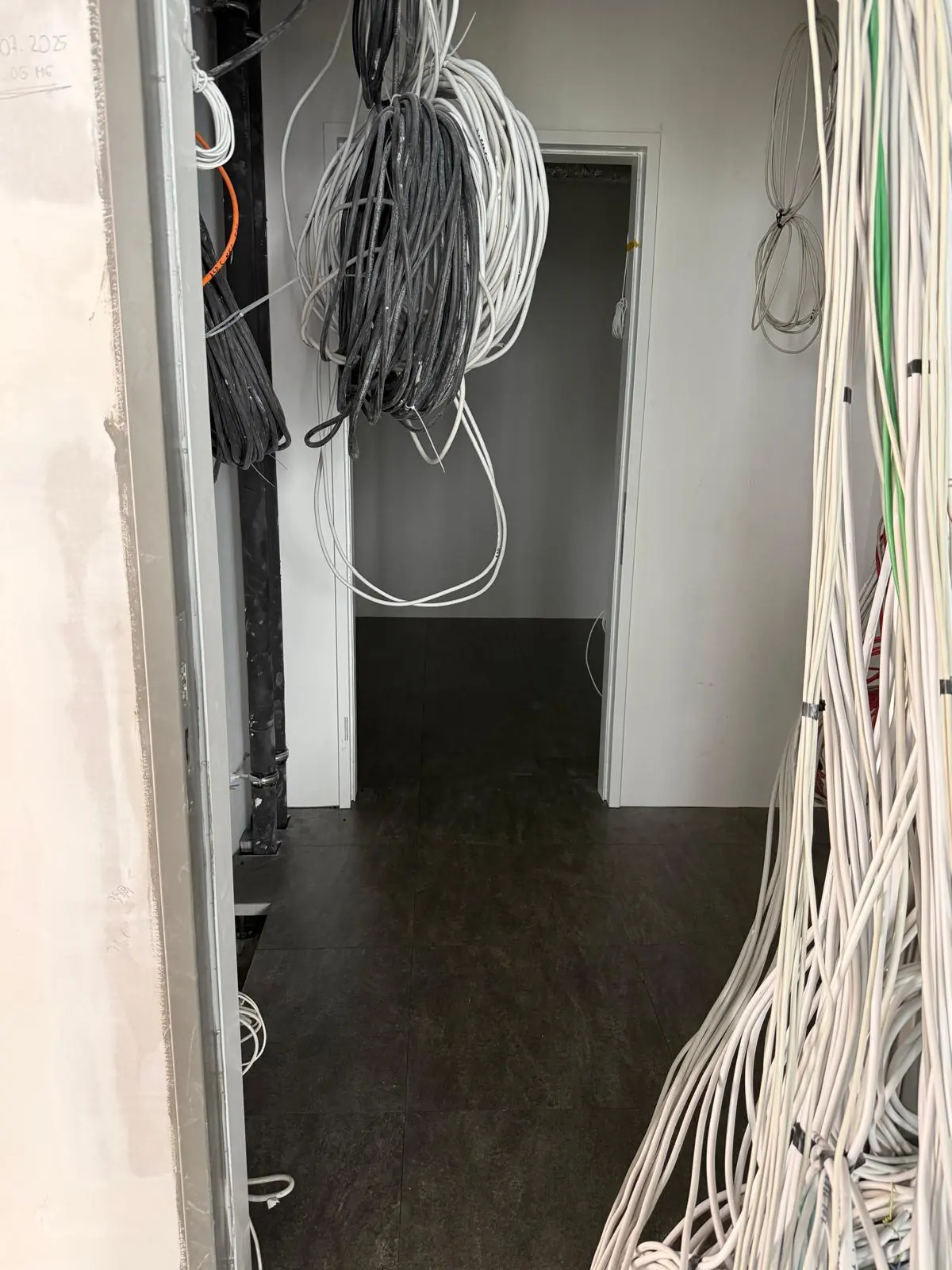 Technikflur mit gebündelten Kabelsträngen über dem fertigen Boden